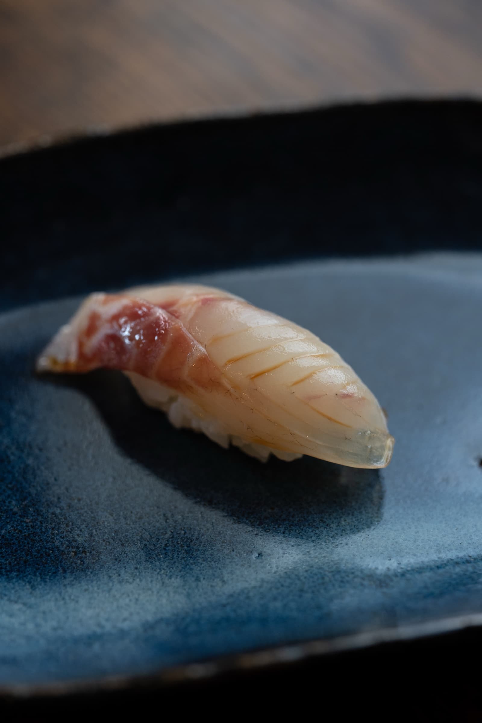 Nigiri sushi prepared by JapaKen, plated on dark ceramic