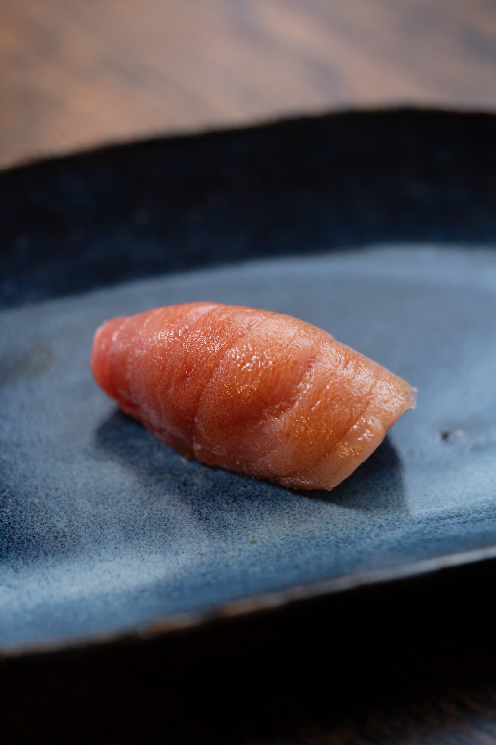 Een stuk nigiri-sushi op donker keramiek